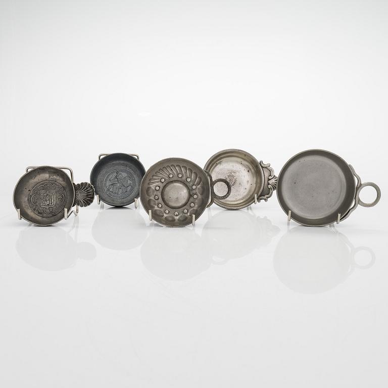 A set of fourteen tastevin cups, pewter and glass, 20th century.