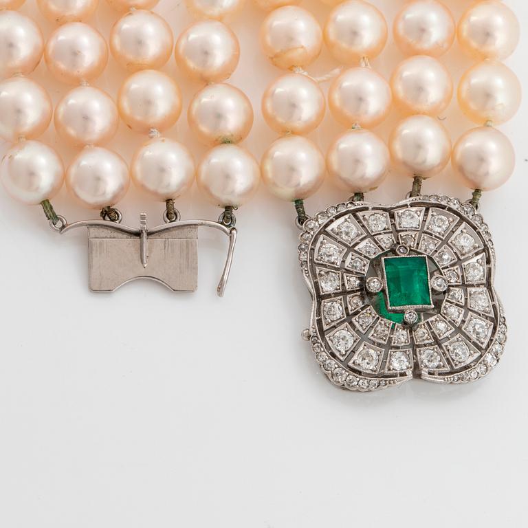 A four strand cultured pearl necklace with an 18K white gold clasp set with a faceted emerald.