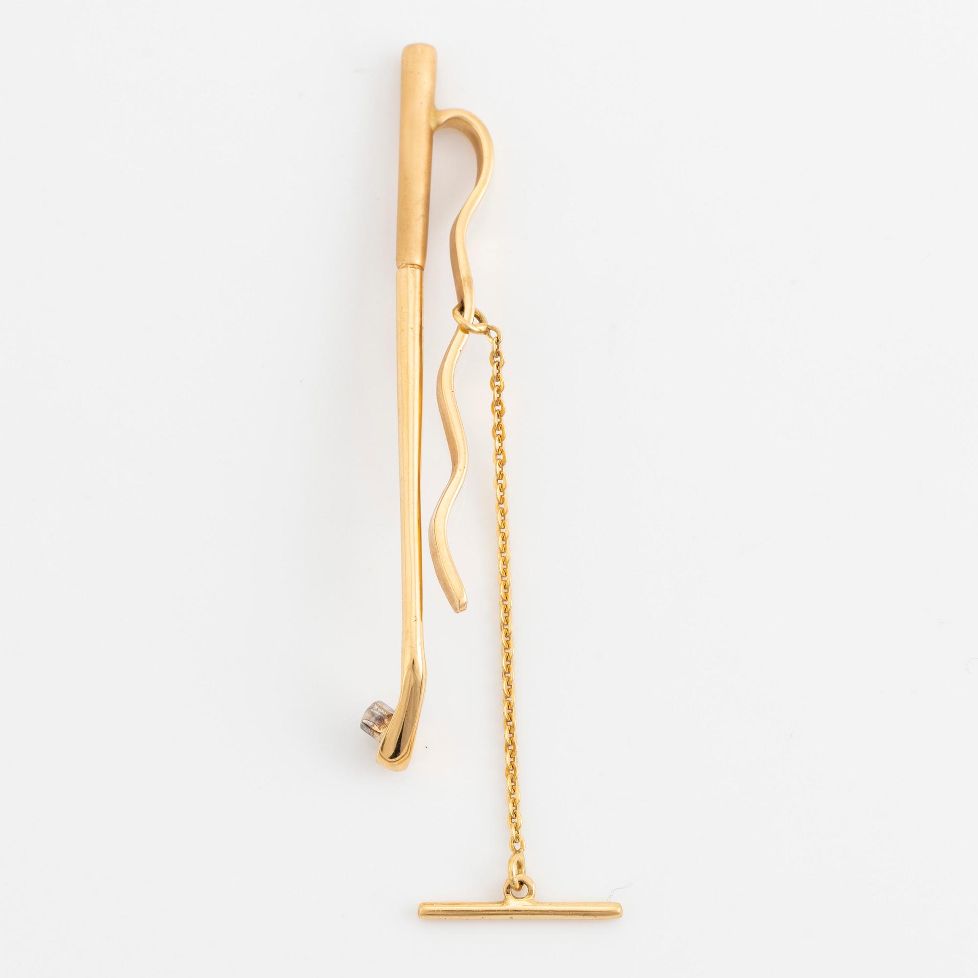 Slipsnål, 18K guld med briljantslipad diamant, i form av en golfklubba.