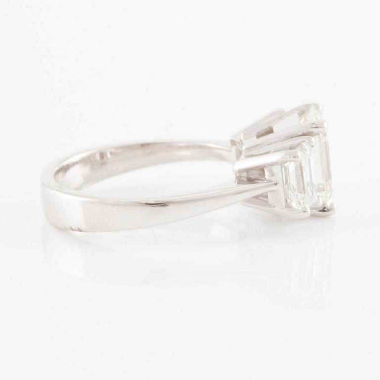 An 18K white gold ring set with three emerald-cut diamonds.