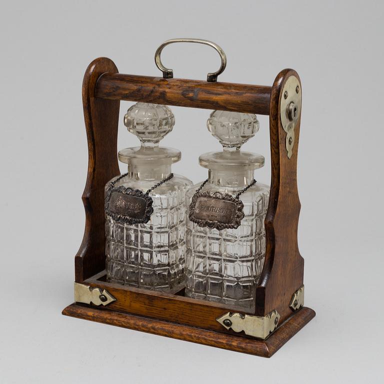 An oak, silver, silverplated and glass tantalus with lock. Second half of the 20th century.