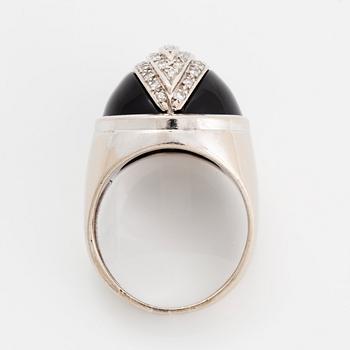 An 18K white gold and onyx ring set with round brilliant-cut diamonds.