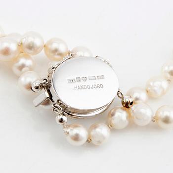 Necklace, double strand of cultured pearls with clasp in 18K white gold and diamonds.