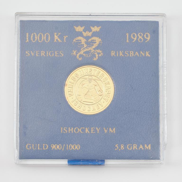 JUBILEUMSMYNT 1000 KRONOR, guld, "Ishockey VM 1989". Totalvikt ca 6 gram.