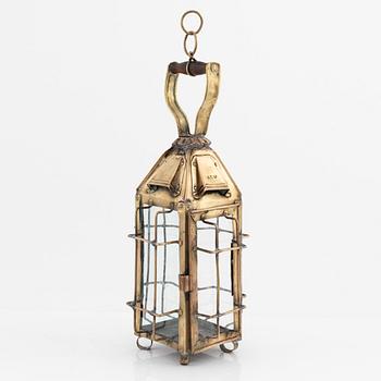 A metal storm lantern, marked A.T, circa 1900.