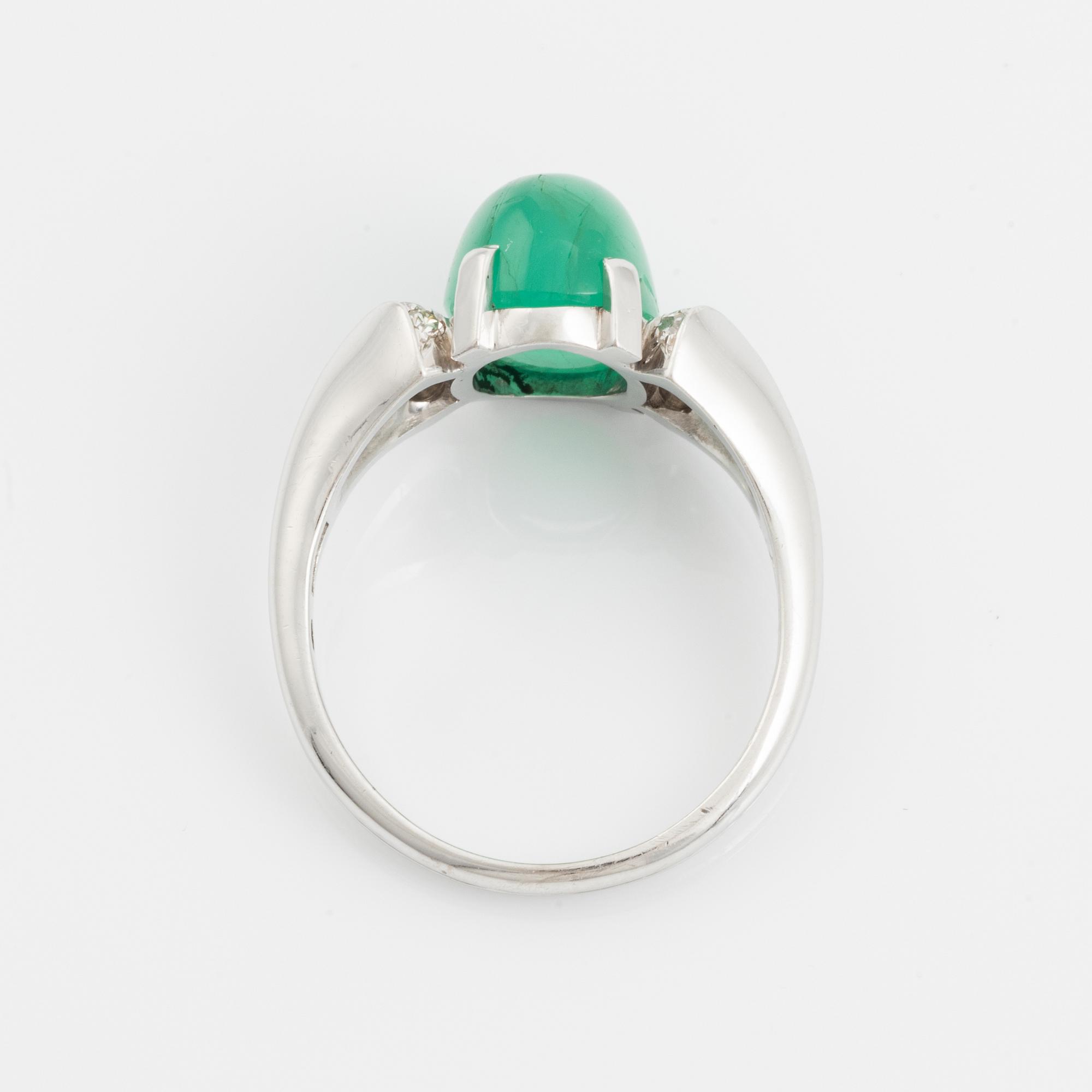 An 18K white gold ring set with a cabochon-cut emerald and eight-cut diamonds.