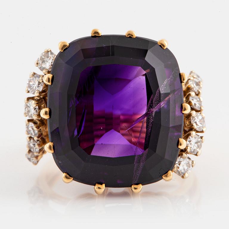 An 18K gold ring set with a faceted amethyst and round brilliant-cut diamonds.