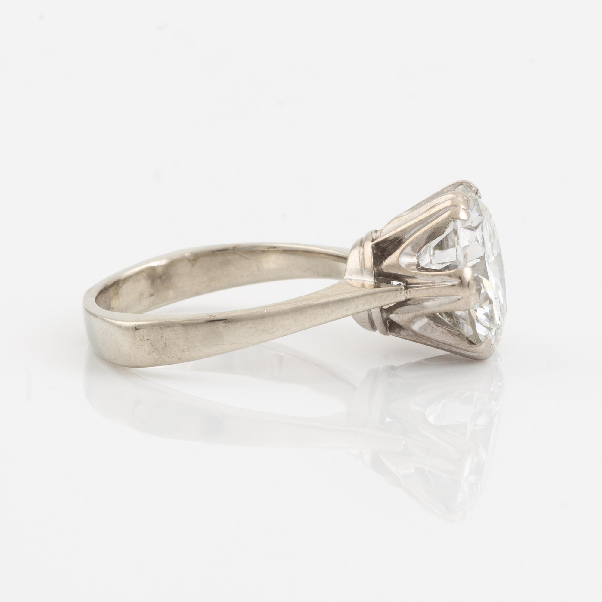 An 18K white gold ring set with a round brilliant-cut diamond.