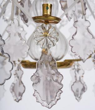 A near pair of rococo-style gilt brass and cut glass six-branch chandeliers, 19th century incorporating older elements.