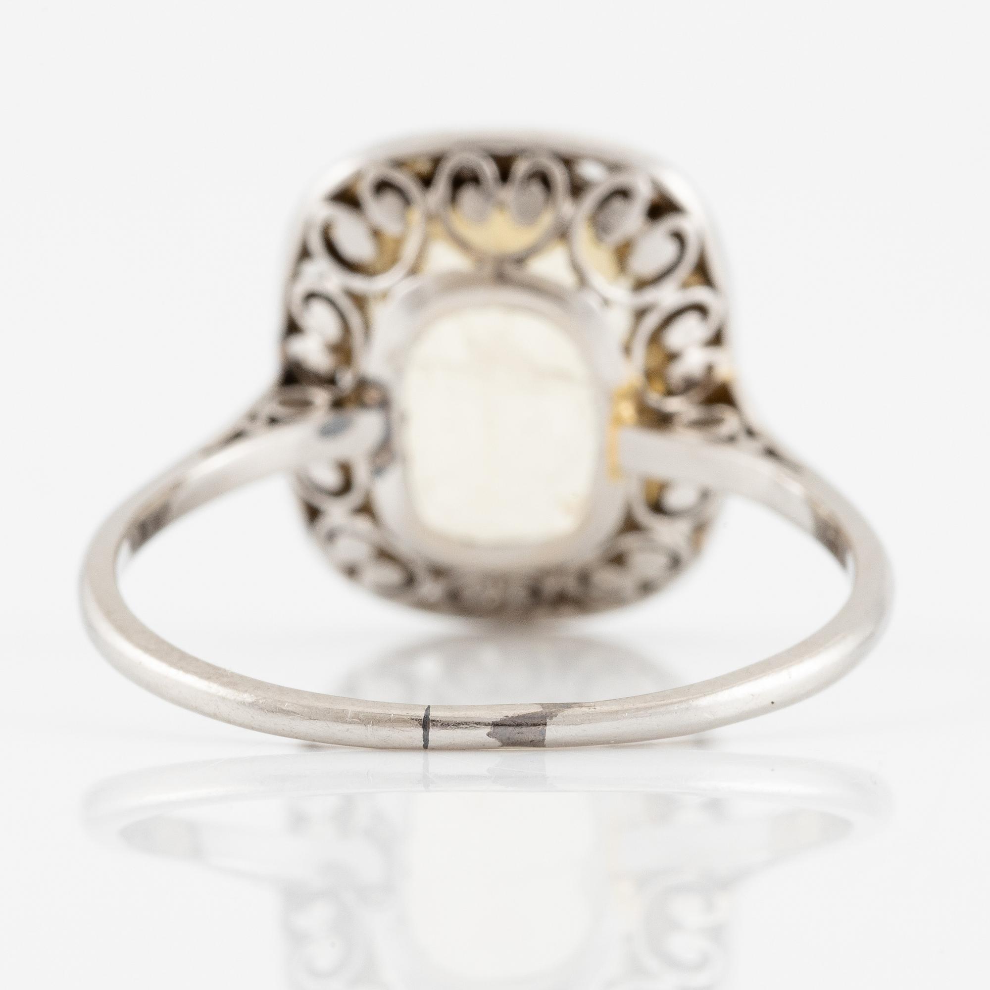 A ring in 18K white gold set with a yellow faceted tourmaline and rose-cut diamonds.