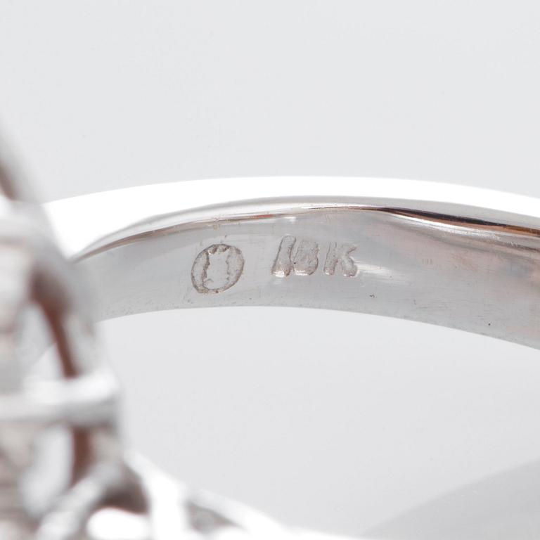 Ring med en fasettslipad spessartingranat samt runda briljantslipade diamanter.