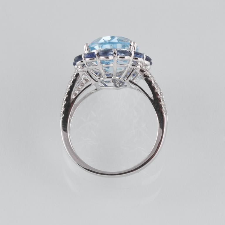 RING, 18K vitguld med briljantslipade diamanter ca 0.24 ct, blå safirer ca 2.05 ct samt topas ca 6.93 ct. Vikt 5,6 g.