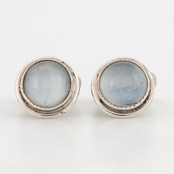 GUSSI, a pair of silver cufflinks set with moonstones.