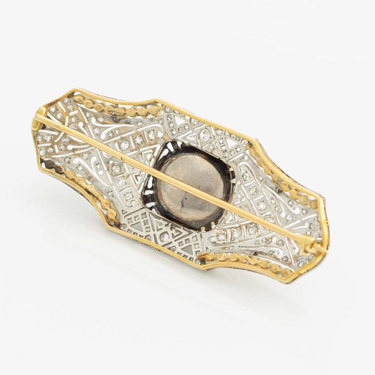 Brooch in 18K gold and platinum with a cultured half-pearl, pearls, diamonds in various cuts, and white stones.