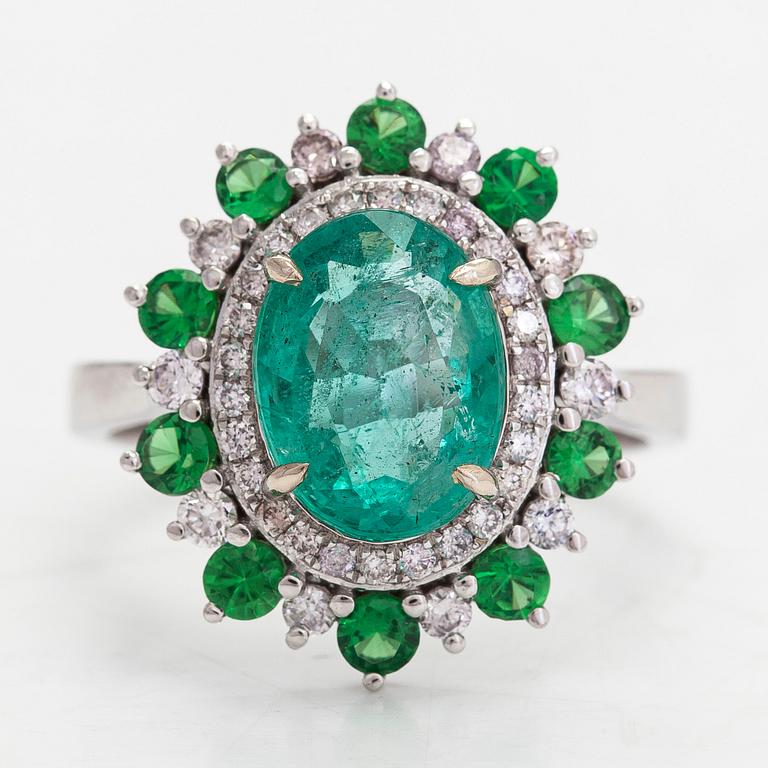 A 14K white gold ring with an emerald 2.40 ct, tsavorites 0.75 ct and diamonds ca 0.42 ct. With IGI certificate.