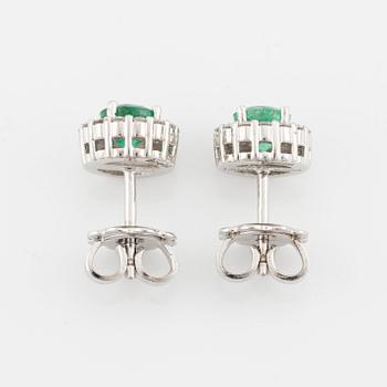 A pair of 18K gold earrings with faceted emeralds and round brilliant-cut diamonds.