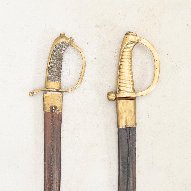 To cutlasses, 19th century, with scabbards.