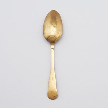 A brass (originally silver plated) spoon by Erik Castman.