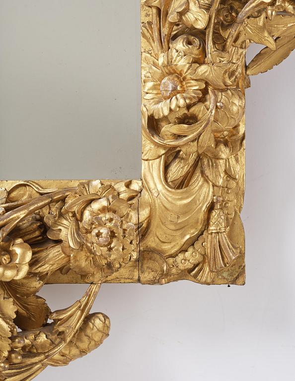 A presumably Dutch Louis XIV carved giltwood frame with mirror glass, in the style of Jean Le Pautre, late 17th century.