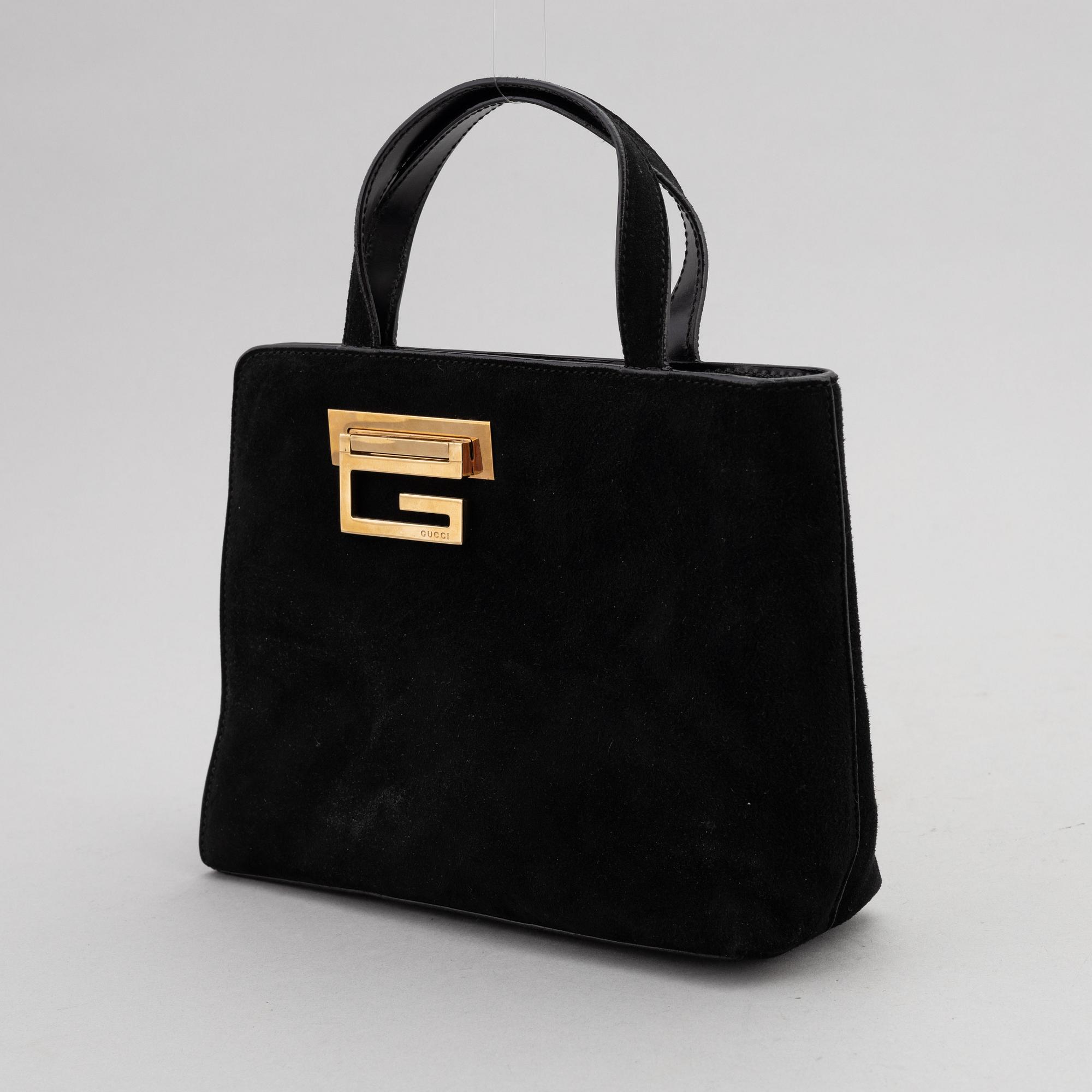 Gucci, a black suede handbag.