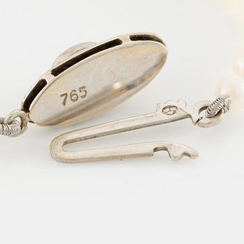 Collier med doserade odlade pärlor, lås 18K vitguld med cabochonslipad smaragd.