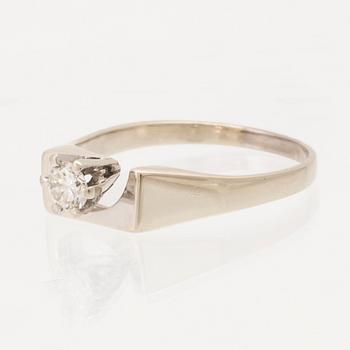 An 18K white gold solitaire ring set with a round brilliant-cut diamond.