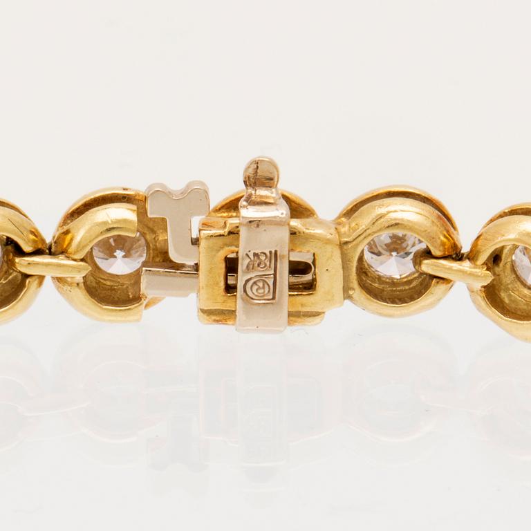 An 18K gold tennis bracelet set with round brilliant cut diamonds.