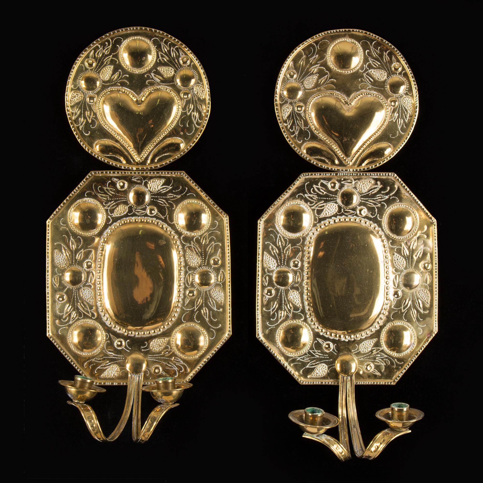 A pair of first half of the 20th century brass two-light wall sconces.