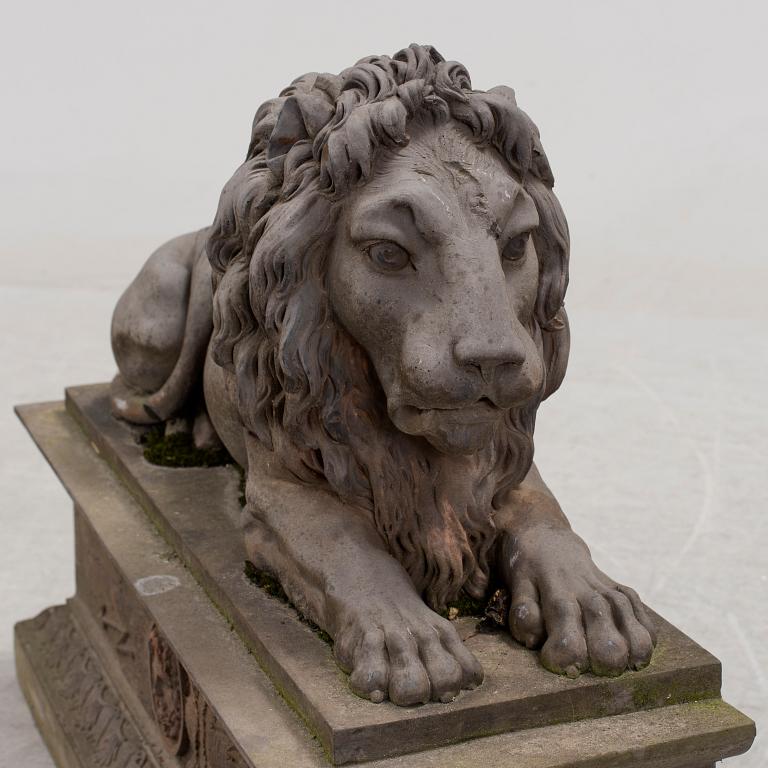 A SCULPTURE/ DECOR-ELEMENT, a lion on a plint, artificial stone, empire-style, late 1900s.