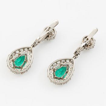 Earrings in platinum with drop-shaped emeralds and brilliant-cut and octagonal-cut diamonds.