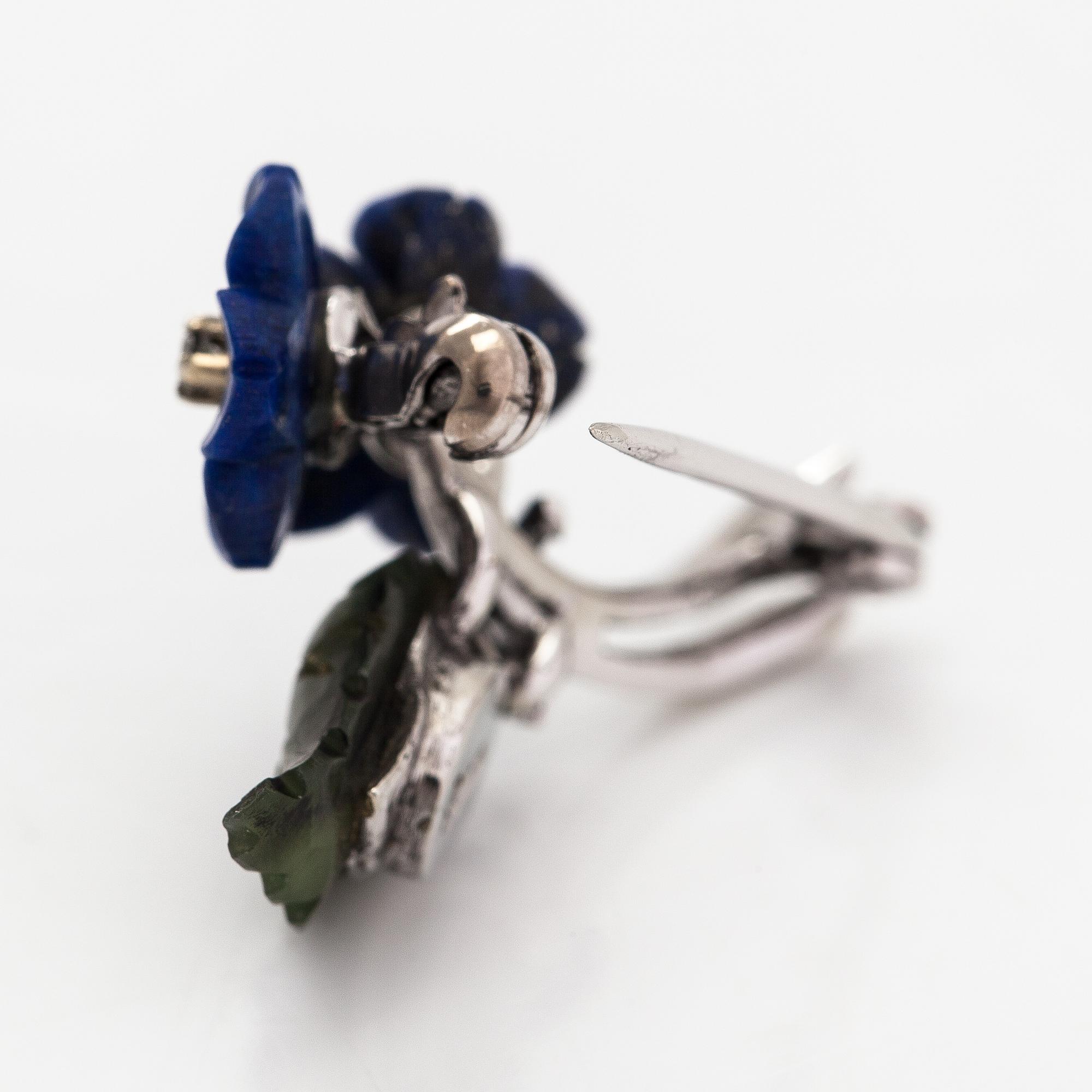 Brosch, nickelhaltigt 18K vitguld, lapis lazuli, nefrit och diamanter ca 0.03 ct totalt.
