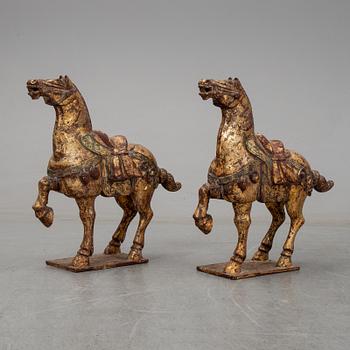 A pair of large Chinese wooden and gilt sculpture of horses, first half of the 20th century.