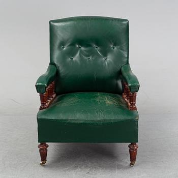 An early 20th Century easy chair with leather upholstery.
