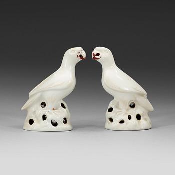 A pair of white and red glazed figures of parrots, late Qing dynasty.