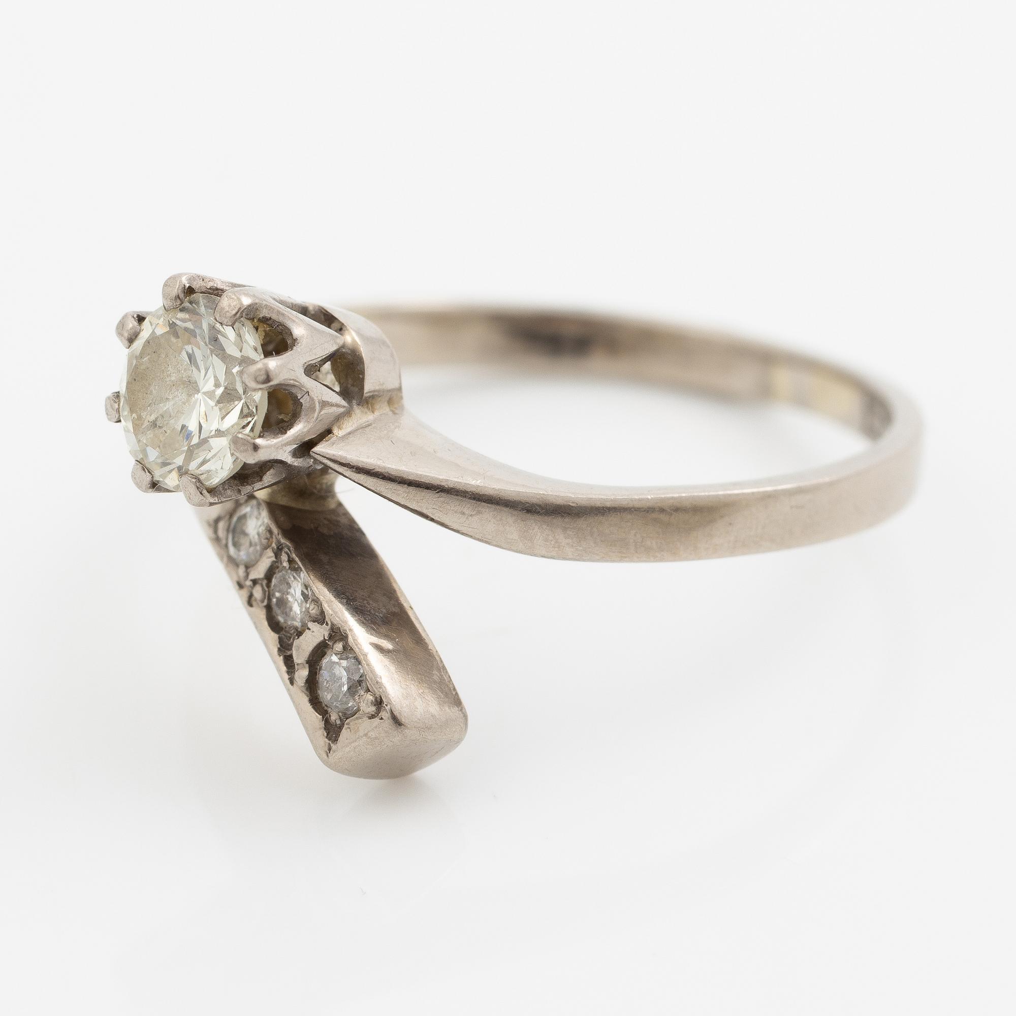 Ring, 18K vitguld med en briljantslipad diamant och  tre mindre briljantslipade diamanter.