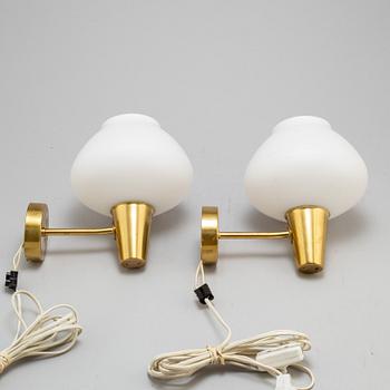 a pair of glass and brass ASEA wall lights from the mid 20th century.