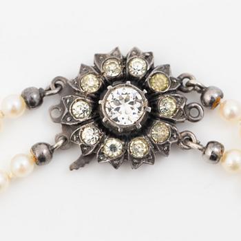 Double-row necklace with graduated cultured pearls, silver clasp set with paste stones.
