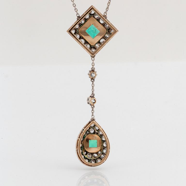 A necklace set with two faceted emeralds and old-cut diamonds.