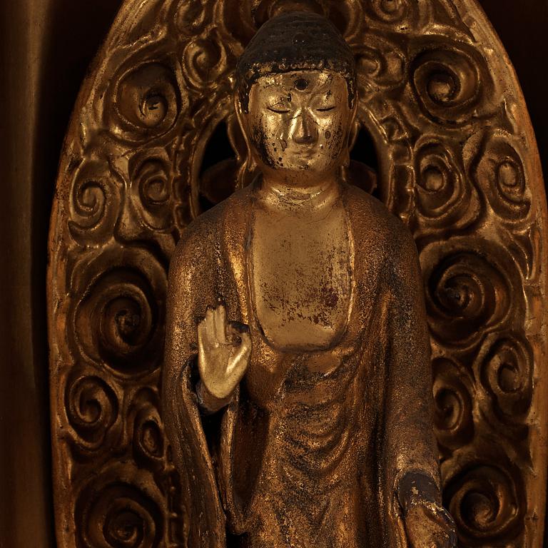 A Japanese gilt wooden figure of standing Buddha in a lacquer shrine, Meiji (1868-1912).