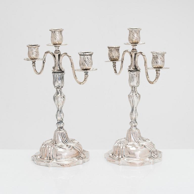 A pair of 18th-century Rococo silver candlesticks from Germany with later candelabra arms. Unindtified maker's mark.
