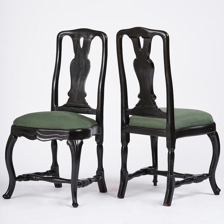 A set of eight black Swedish rococo chairs.