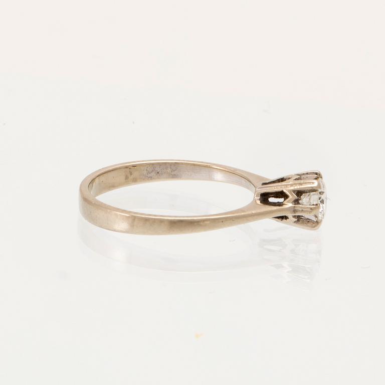 An 18K white gold solitaire ring set with a round brilliant-cut diamond.
