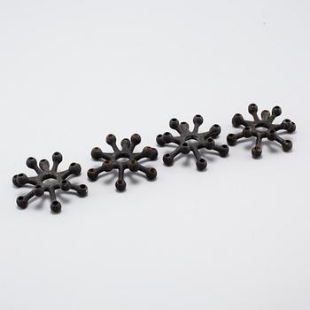 Four 1960s iron cast candle holders, designed by Jens Quistgaard for Dansk Designs .