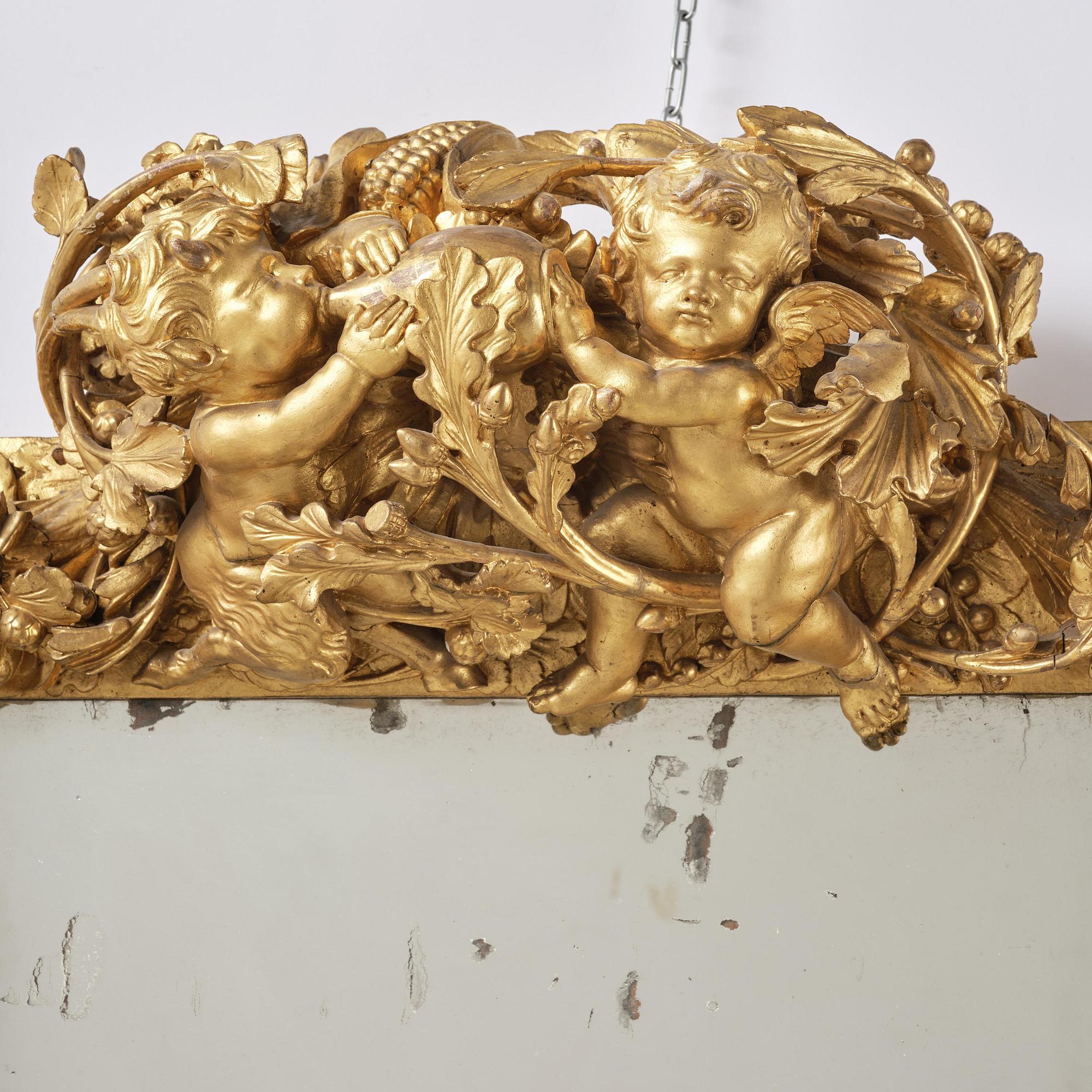 A presumably Dutch Louis XIV carved giltwood frame with mirror glass, in the style of Jean Le Pautre, late 17th century.