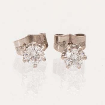 A pair of 18K white gold earrings set with round brilliant cut diamonds.