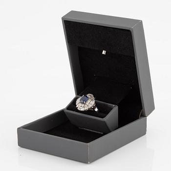 Ring in platinum set with a faceted sapphire and round brilliant- and baguette-cut diamonds.