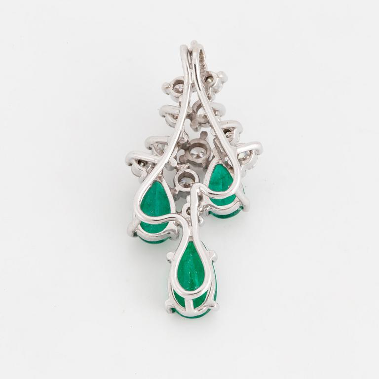 An 18K white gold emerald and diamond pendant.