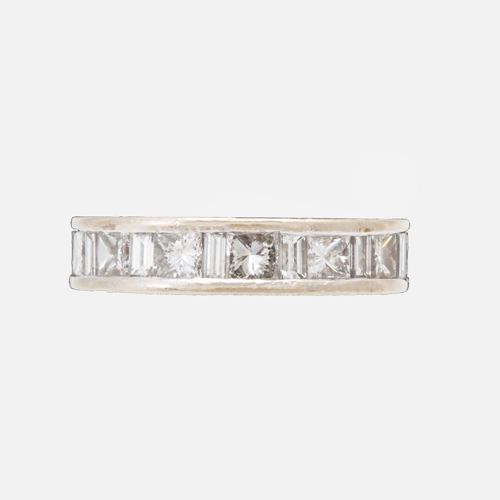 An 18K white gold eternity ring set with baguette and princess cut diamonds by Hartmann's Denmark.