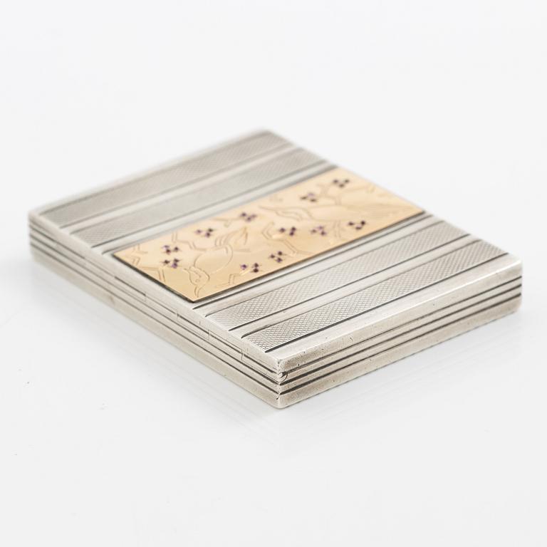 Puderdosa, silver samt guld. Med dekor av fåglar och rosa stenar.