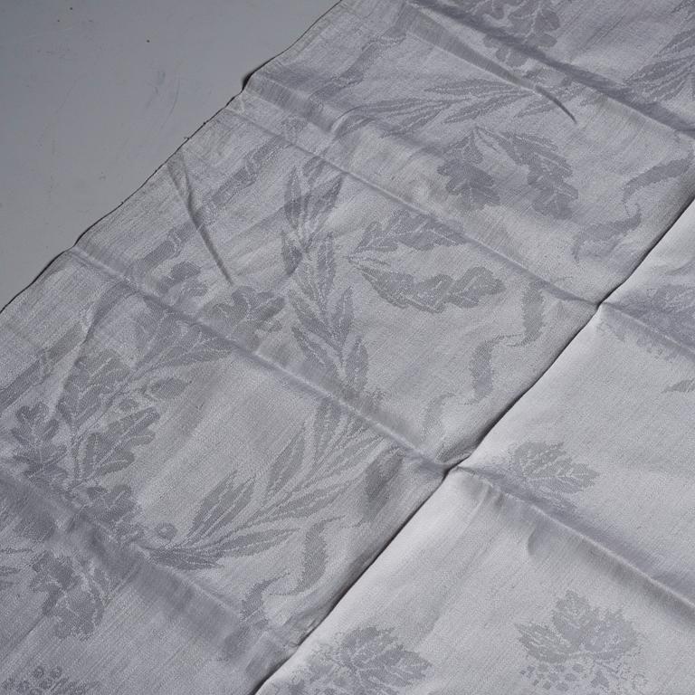 A tea table cloth, linen damask, "Lilla blomsterkorgen", ca 143,5 x 144 cm.